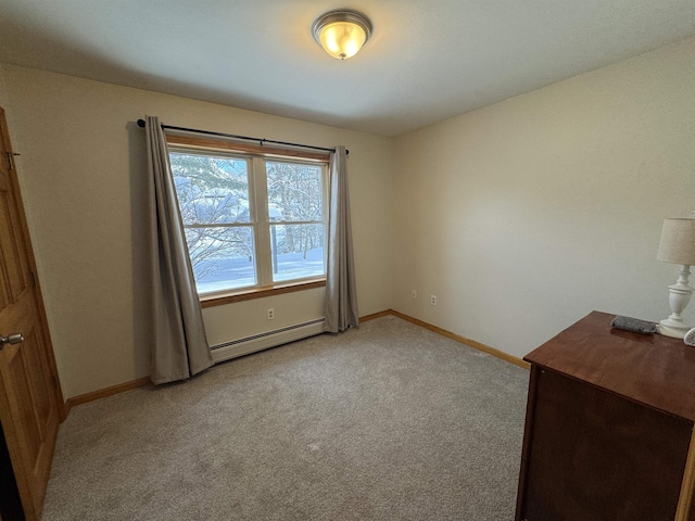 unfurnished room with a baseboard heating unit and light colored carpet