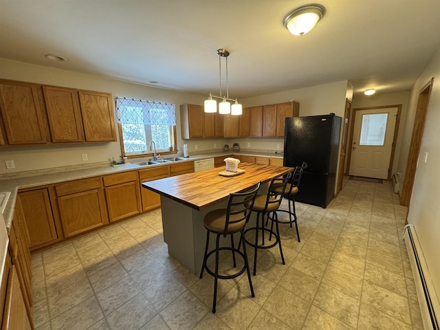 kitchen with sink, black fridge, a center island, baseboard heating, and pendant lighting