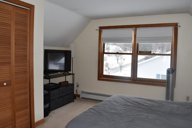 carpeted bedroom with multiple windows, vaulted ceiling, baseboard heating, and a closet