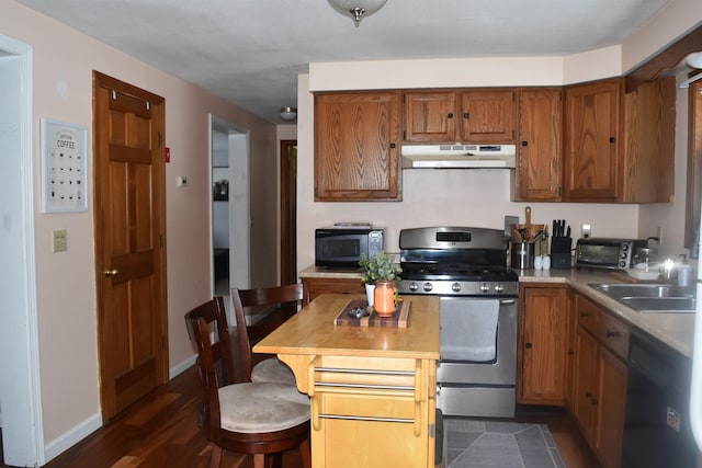 kitchen featuring sink, dark wood-type flooring, black appliances, and a breakfast bar