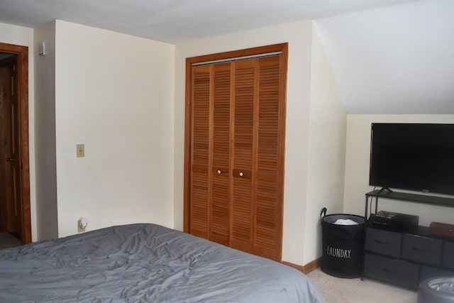 carpeted bedroom with vaulted ceiling and a closet