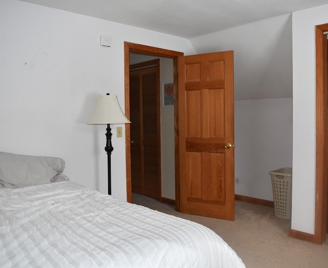 carpeted bedroom with lofted ceiling and a closet