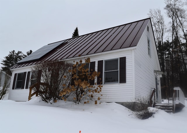 view of snow covered exterior with solar panels