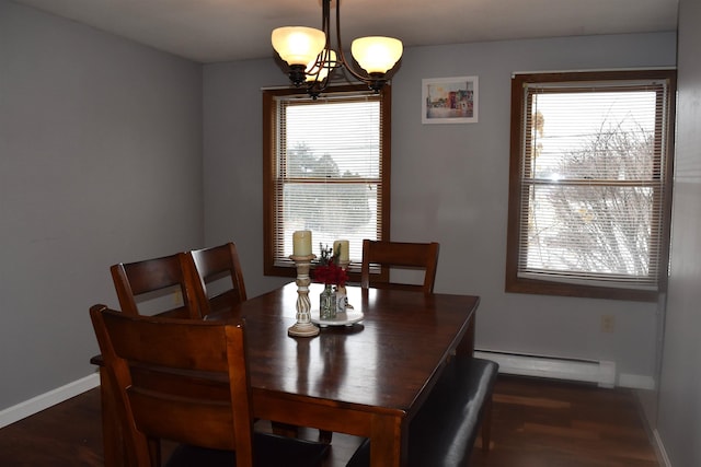 dining room featuring dark hardwood / wood-style flooring, a baseboard heating unit, and an inviting chandelier