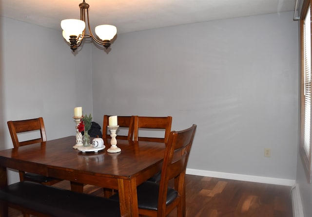 dining room featuring dark wood-type flooring and a chandelier