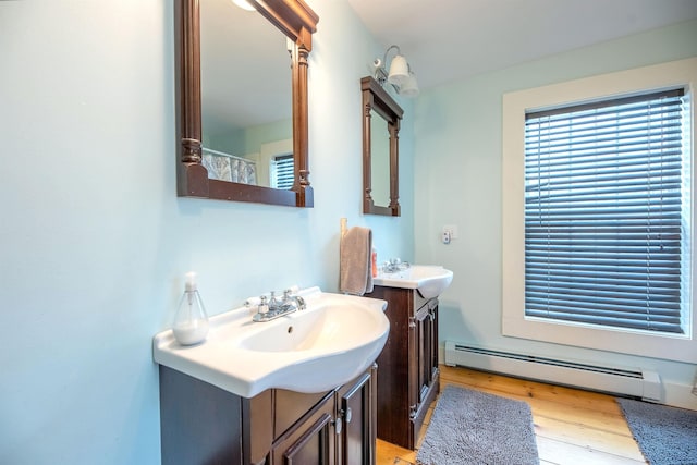 bathroom with a baseboard radiator, wood-type flooring, and vanity