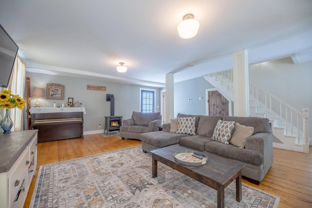 living room featuring a wood stove and light hardwood / wood-style flooring