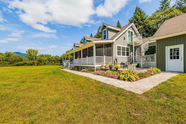 rear view of house with a yard and a sunroom