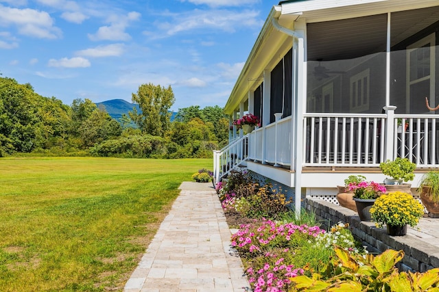 view of side of home with a lawn and a sunroom