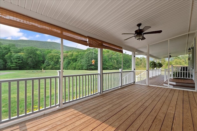 wooden deck featuring ceiling fan and a lawn