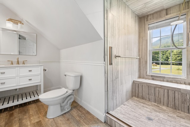 bathroom with hardwood / wood-style flooring, vanity, vaulted ceiling, toilet, and walk in shower