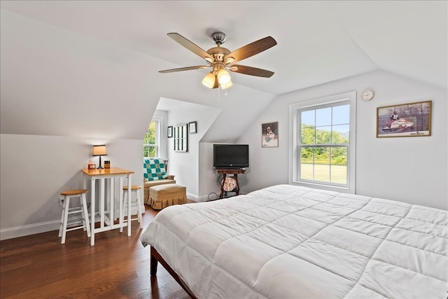 bedroom featuring multiple windows, vaulted ceiling, dark hardwood / wood-style floors, and ceiling fan