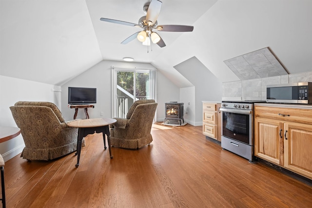 interior space featuring ceiling fan, wood-type flooring, and vaulted ceiling