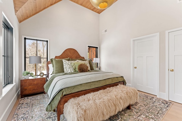 bedroom with hardwood / wood-style flooring, wooden ceiling, and high vaulted ceiling