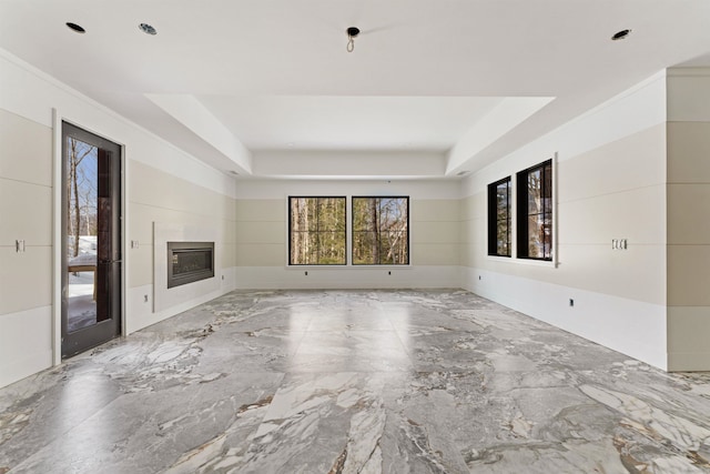 unfurnished living room with a raised ceiling