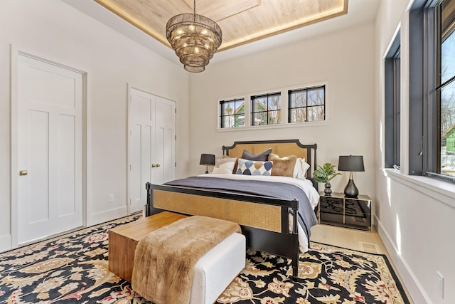 bedroom with a raised ceiling and a notable chandelier