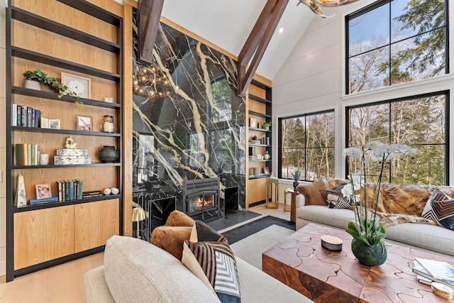 living room featuring built in shelves, wood-type flooring, a fireplace, and high vaulted ceiling