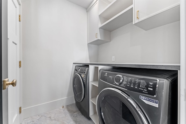 washroom with cabinets and washer and dryer