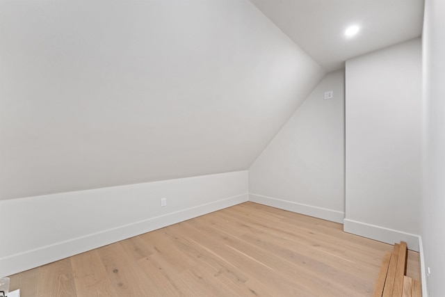 additional living space featuring lofted ceiling and hardwood / wood-style flooring