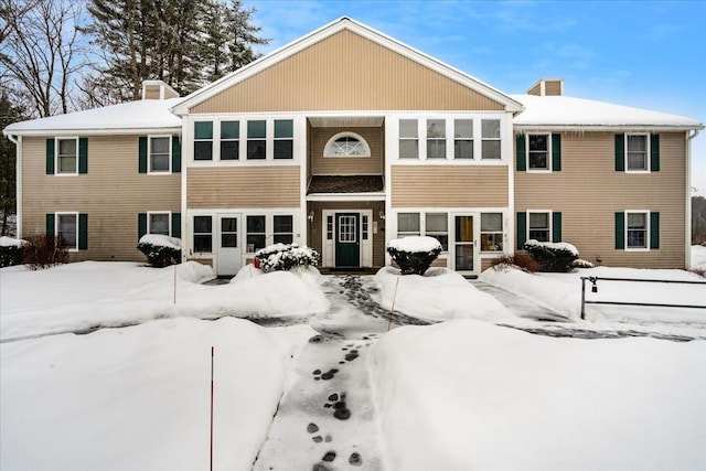 view of snow covered back of property