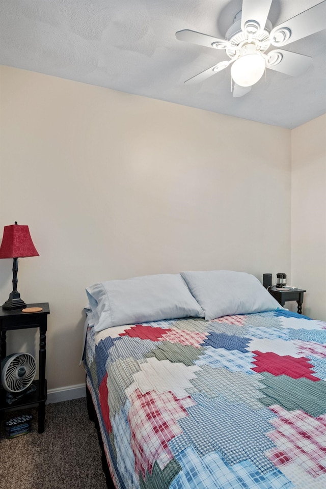 bedroom with ceiling fan and dark carpet