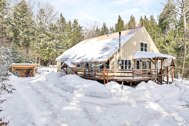 snow covered rear of property featuring a deck