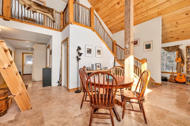 dining space with a high ceiling and wooden ceiling