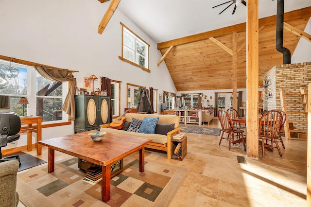 living room with high vaulted ceiling, a wood stove, and beam ceiling