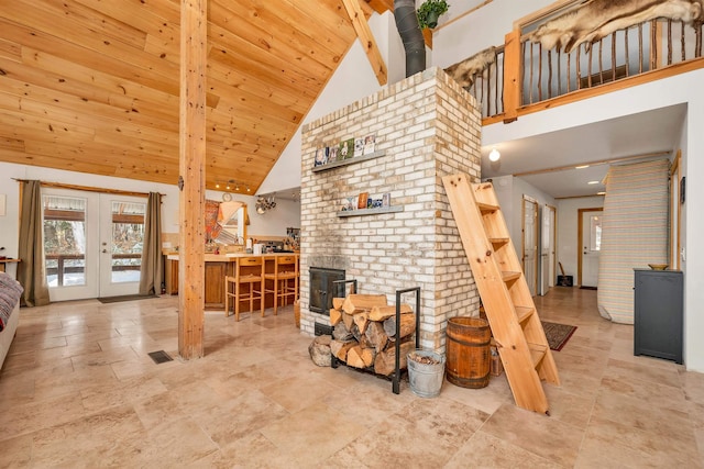 living room with high vaulted ceiling, a wood stove, wood ceiling, and french doors