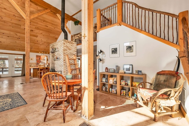 interior space with high vaulted ceiling, wooden ceiling, french doors, beamed ceiling, and a wood stove