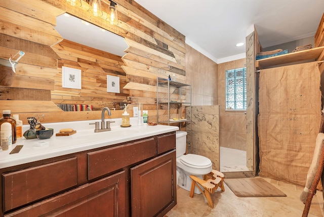 bathroom with vanity, tiled shower, and toilet