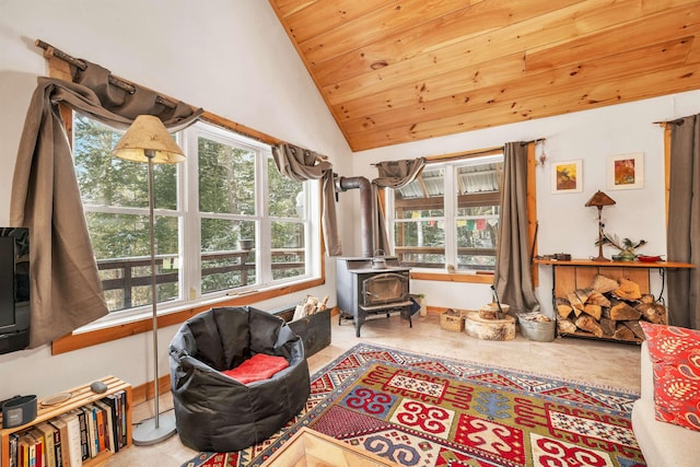 living area with wood ceiling, plenty of natural light, lofted ceiling, and a wood stove