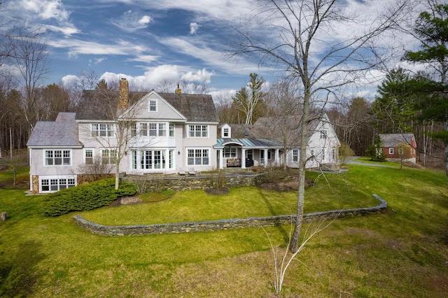 rear view of property featuring a garage and a yard