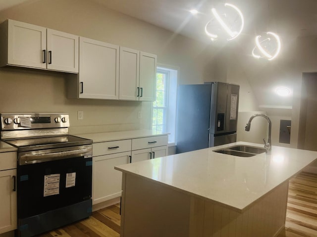 kitchen with white cabinetry, appliances with stainless steel finishes, sink, and an island with sink