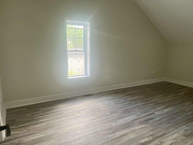 bonus room with lofted ceiling and dark hardwood / wood-style flooring