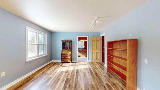 interior space with light hardwood / wood-style floors and rail lighting