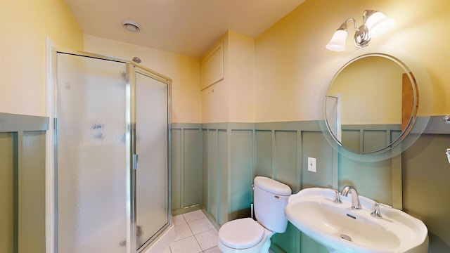 bathroom with an enclosed shower, sink, tile patterned floors, and toilet