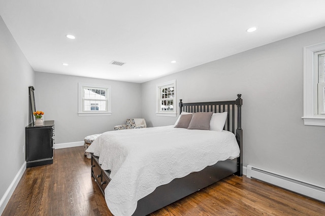 bedroom featuring a baseboard heating unit and dark wood-type flooring