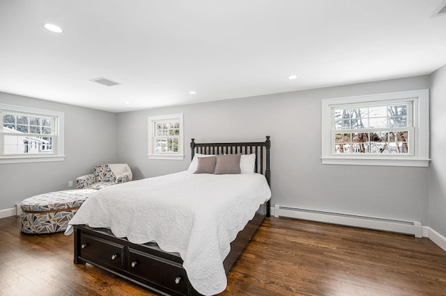 bedroom featuring a baseboard heating unit and dark wood-type flooring