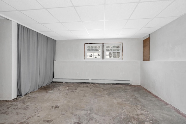 basement with a drop ceiling and a baseboard heating unit