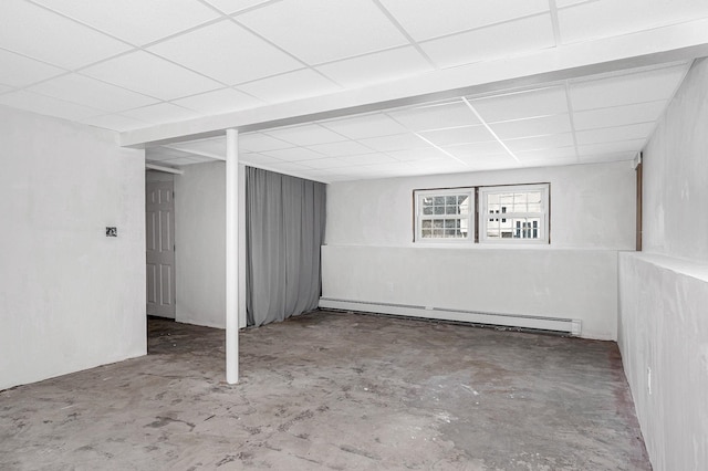 basement featuring a drop ceiling and a baseboard radiator