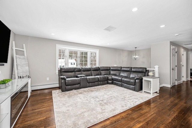 living room with an inviting chandelier, dark hardwood / wood-style flooring, and baseboard heating