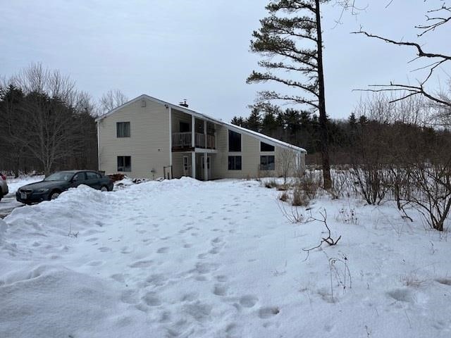 view of snow covered rear of property