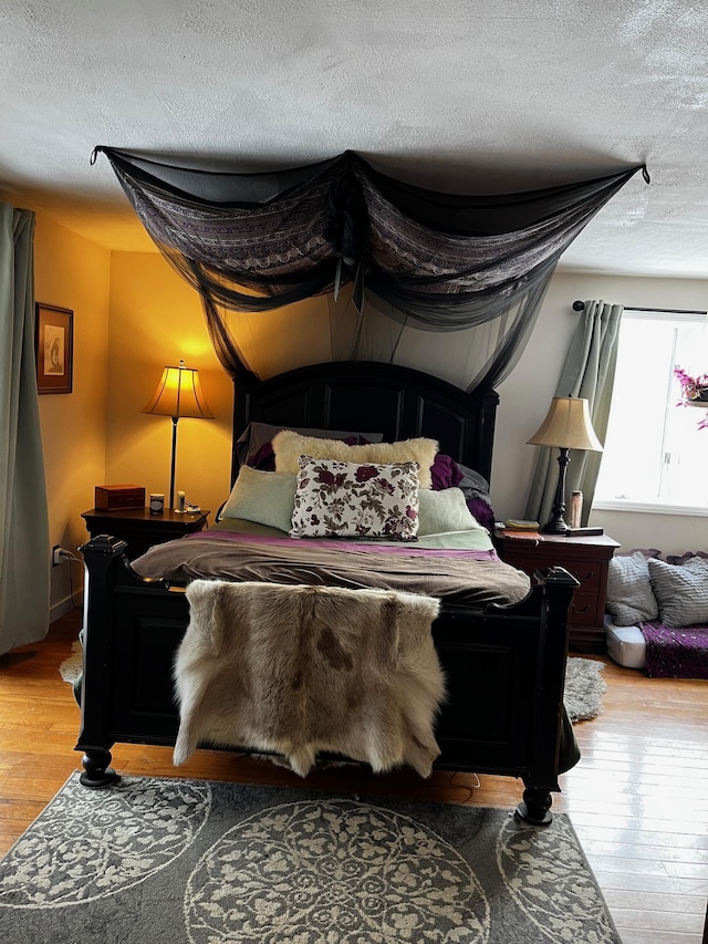 bedroom with light wood finished floors and a textured ceiling