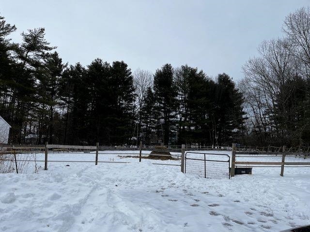 yard covered in snow featuring fence