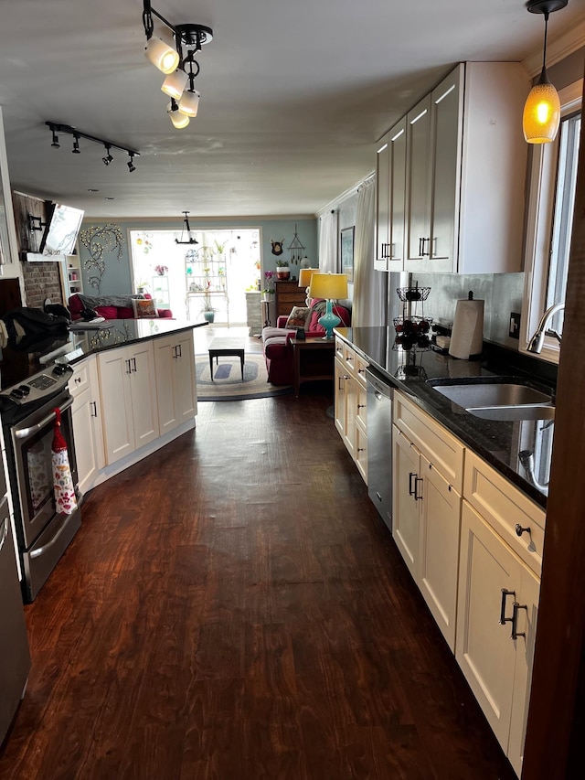 kitchen featuring white cabinets, dark wood-style floors, appliances with stainless steel finishes, open floor plan, and hanging light fixtures