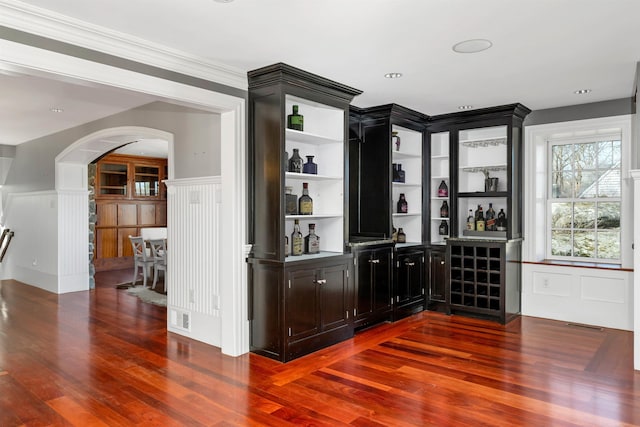 bar featuring ornamental molding and hardwood / wood-style floors