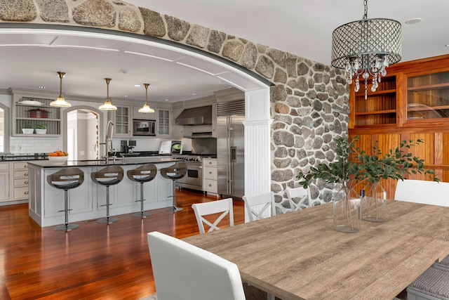 dining space with an inviting chandelier, sink, and dark hardwood / wood-style floors