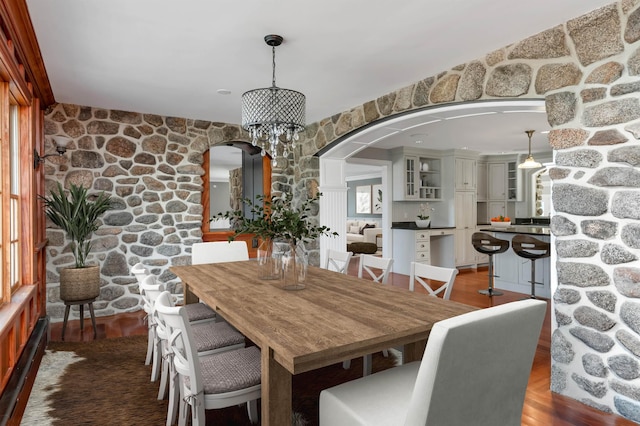 dining area with dark hardwood / wood-style flooring and an inviting chandelier