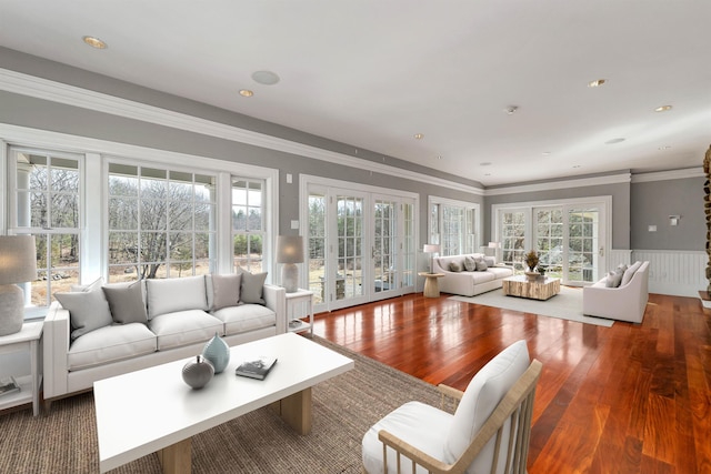 living room with hardwood / wood-style flooring, ornamental molding, and french doors